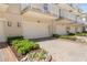 Townhome exterior featuring well-kept landscaping, brick paved driveway and attached garages under private balconies at 661 Hangnest Ln, Lake Mary, FL 32746