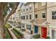 Inviting townhouse complex with well-manicured landscaping, colorful doors, and tiled roofs at 661 Hangnest Ln, Lake Mary, FL 32746
