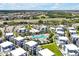 Aerial view of the townhome community with pool, parking, and manicured landscaping against a scenic backdrop at 7770 Sandy Ridge Dr # 117, Reunion, FL 34747