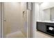 Modern bathroom featuring glass shower, light tile, and dark cabinets with towels inside at 7770 Sandy Ridge Dr # 117, Reunion, FL 34747
