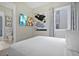 Bedroom with modern art, TV, and view into bathroom, showcasing contemporary design and comfortable space at 7770 Sandy Ridge Dr # 117, Reunion, FL 34747