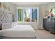 Bright bedroom with a large tufted headboard and view to the exterior, offers comfort and natural light at 7770 Sandy Ridge Dr # 117, Reunion, FL 34747