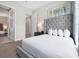 Spacious bedroom with grey, tufted headboard and modern furnishings, creating a stylish and comfortable retreat at 7770 Sandy Ridge Dr # 117, Reunion, FL 34747
