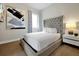 Bedroom with a large, tufted headboard, white bedding, and modern nightstand, illuminated by soft natural light at 7770 Sandy Ridge Dr # 117, Reunion, FL 34747