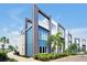 Modern condo building with a sleek design, featuring blue accents, balconies, and lush landscaping at 7770 Sandy Ridge Dr # 117, Reunion, FL 34747