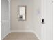 Inviting condo hallway with tiled floors, a mirror reflecting the kitchen, and white doors at 7770 Sandy Ridge Dr # 117, Reunion, FL 34747