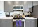 Close-up of the modern gray kitchen cabinets, stainless steel stove, oven and microwave appliances at 7770 Sandy Ridge Dr # 117, Reunion, FL 34747