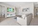 Bright living room featuring modern decor, a comfortable sofa, and an adjacent bathroom at 7770 Sandy Ridge Dr # 117, Reunion, FL 34747