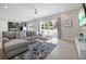 Open-concept living room featuring a comfortable sectional sofa, TV, and access to the patio at 7770 Sandy Ridge Dr # 117, Reunion, FL 34747