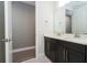 Bathroom with a double sink vanity, a quartz countertop, and a view into another room at 8066 Ludington Cir, Orlando, FL 32836