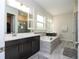 Bathroom boasts double vanity, tub, and shower, complemented by bright light at 8066 Ludington Cir, Orlando, FL 32836