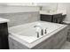 Bathroom featuring a tub with a chrome faucet and elegant grey tiled flooring at 8066 Ludington Cir, Orlando, FL 32836