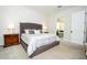 Bedroom with grey headboard, two nightstands, and a view of the bathroom at 8066 Ludington Cir, Orlando, FL 32836