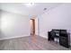 Bedroom with an open doorway, clean walls, wood-look floors, a bright window, and a dark colored desk at 8066 Ludington Cir, Orlando, FL 32836