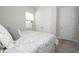 Well-lit bedroom with carpet, closet and bed with a grey and white cover at 8066 Ludington Cir, Orlando, FL 32836