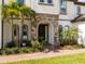 Charming front entrance adorned with stone accents, arched doorway, and beautifully landscaped surroundings at 8066 Ludington Cir, Orlando, FL 32836