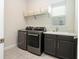 Laundry room with modern appliances, storage cabinets, and a utility sink at 8066 Ludington Cir, Orlando, FL 32836