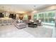 Open-concept living room featuring modern gray decor and sliding glass doors to the pool area at 8066 Ludington Cir, Orlando, FL 32836