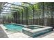 Inviting screened-in pool and spa with a view of lush, tropical bamboo landscaping at 8066 Ludington Cir, Orlando, FL 32836