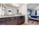 Bright bathroom with a dual-sink vanity featuring granite countertops and dark wood cabinets, with bedroom view at 8806 Geneve Ct, Kissimmee, FL 34747
