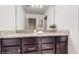 Bathroom showcasing dual sinks with granite counters, modern lighting, and access to bedroom with a door at 8806 Geneve Ct, Kissimmee, FL 34747