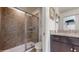 Modern bathroom with a glass-enclosed shower, granite vanity top, and neutral tile at 8806 Geneve Ct, Kissimmee, FL 34747