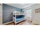 Bedroom featuring white bunk beds with blue bedding, wood floors, and a window at 8806 Geneve Ct, Kissimmee, FL 34747