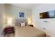 Bedroom with a cozy bed, soft lighting from side lamps, and a mounted television at 8806 Geneve Ct, Kissimmee, FL 34747