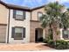 Charming two-story townhome with a red brick driveway and lush tropical landscaping at 8806 Geneve Ct, Kissimmee, FL 34747