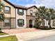 Inviting two-story townhome showcasing a red brick driveway and well-maintained landscaping at 8806 Geneve Ct, Kissimmee, FL 34747
