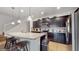 Modern kitchen featuring dark cabinetry, stainless appliances, and a granite island with barstool seating at 8806 Geneve Ct, Kissimmee, FL 34747