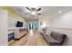 Cozy living room featuring light wood floors, a ceiling fan, and a stylish gray sofa at 8806 Geneve Ct, Kissimmee, FL 34747