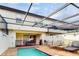 Screened-in pool area with brick patio, lounge chairs, and access to the home's interior at 8806 Geneve Ct, Kissimmee, FL 34747