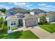 Charming two-story home featuring a well-manicured lawn, inviting curb appeal, and an attached two-car garage at 965 Maypole Dr, Apopka, FL 32703