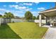 Expansive backyard with lush lawn, a fire pit, storage shed, privacy fence, and covered patio with a built-in grill at 965 Maypole Dr, Apopka, FL 32703