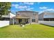 Rear exterior showcasing a spacious backyard featuring a fire pit, covered patio, and full privacy fence, perfect for gatherings at 965 Maypole Dr, Apopka, FL 32703