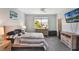 This bright bedroom features a ceiling fan, TV, and a picturesque view from the window at 965 Maypole Dr, Apopka, FL 32703