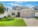Charming two-story home featuring a well-manicured lawn, inviting curb appeal, and an attached two-car garage at 965 Maypole Dr, Apopka, FL 32703