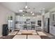 Modern kitchen boasts white cabinetry, stainless steel appliances, a center island, and sliding door access to the backyard at 965 Maypole Dr, Apopka, FL 32703