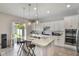 Stylish kitchen showcases white cabinets, a center island with seating, stainless steel appliances, and backyard access at 965 Maypole Dr, Apopka, FL 32703