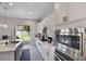 Modern kitchen boasts stainless steel appliances, white cabinets, long countertops, and backyard access at 965 Maypole Dr, Apopka, FL 32703
