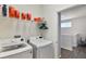 Laundry room featuring modern washer and dryer units, with shelving for supplies at 965 Maypole Dr, Apopka, FL 32703