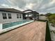 Inviting backyard with a pool, wood patio, and covered outdoor seating area, perfect for entertaining at 9863 Summerlake Groves St, Winter Garden, FL 34787