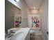 Bright bathroom with a white vanity, a colorful shower curtain, and tile flooring at 9863 Summerlake Groves St, Winter Garden, FL 34787