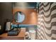 Stylish powder room with a modern sink, round mirror, eye-catching accent wall, and sleek fixtures at 9863 Summerlake Groves St, Winter Garden, FL 34787