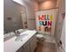 Cozy bathroom featuring a vanity with a white countertop, a tub with a colorful curtain, and kid-friendly decor at 9863 Summerlake Groves St, Winter Garden, FL 34787