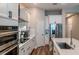 Open kitchen with stainless steel appliances, white cabinets, an island and hardwood floors at 9863 Summerlake Groves St, Winter Garden, FL 34787