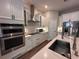 Modern kitchen with stainless steel appliances, quartz countertops, white cabinetry, and wood floors at 9863 Summerlake Groves St, Winter Garden, FL 34787