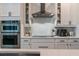 Modern kitchen featuring white cabinets, stainless steel appliances, subway tile backsplash and sleek hardware at 9863 Summerlake Groves St, Winter Garden, FL 34787