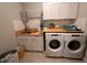 Well-organized laundry room with ample counter space, white cabinets, subway tile backsplash, and modern appliances at 9863 Summerlake Groves St, Winter Garden, FL 34787